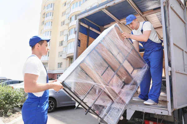 depositphotos_395376696-stock-photo-loaders-taking-furniture-truck